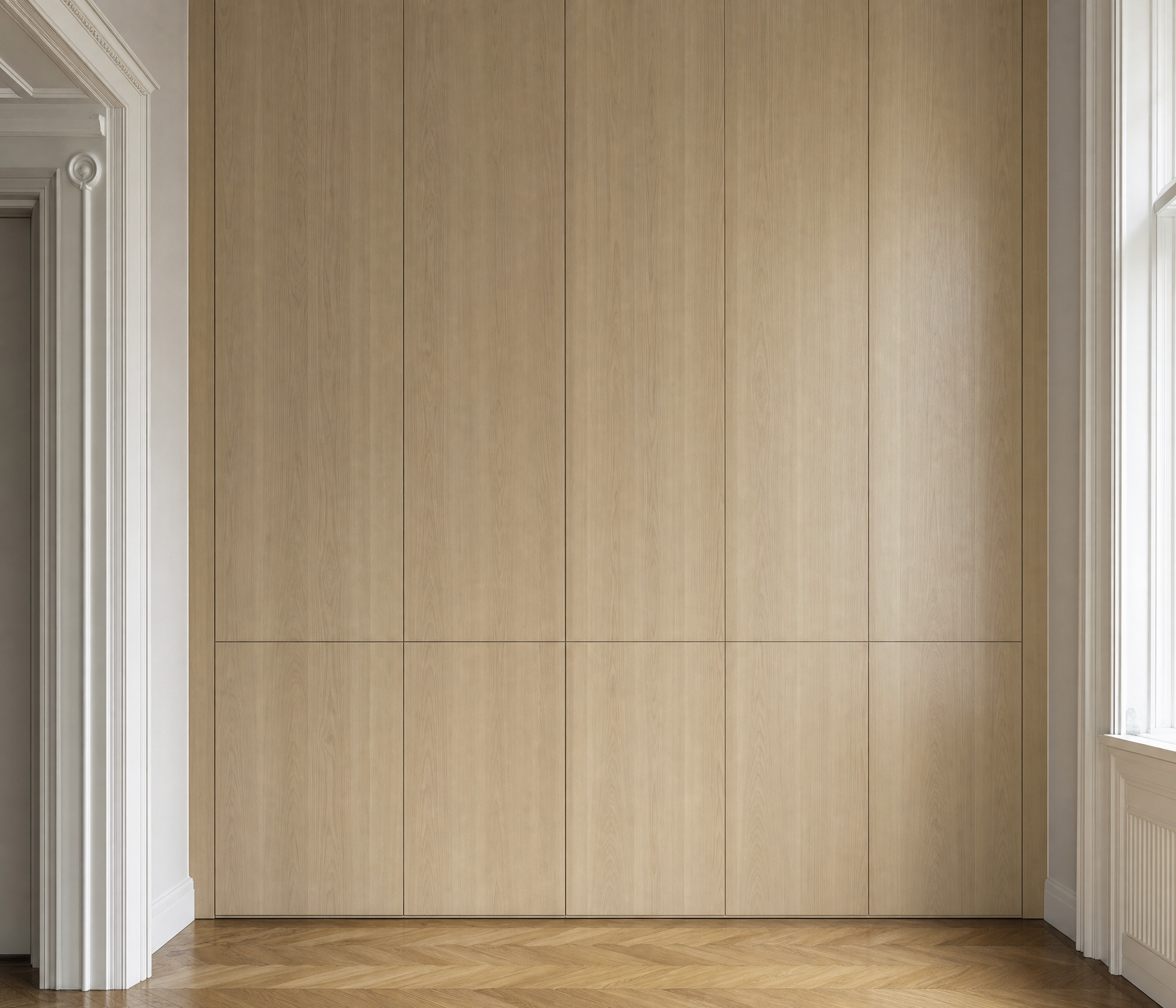 Raumhoher maßgefertigter Einbauschrank aus hellem Eichenholz in einer Altbauwohnung
